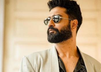 Vicky Kaushal wearing sunglasses and a beige blazer, looking away confidently.